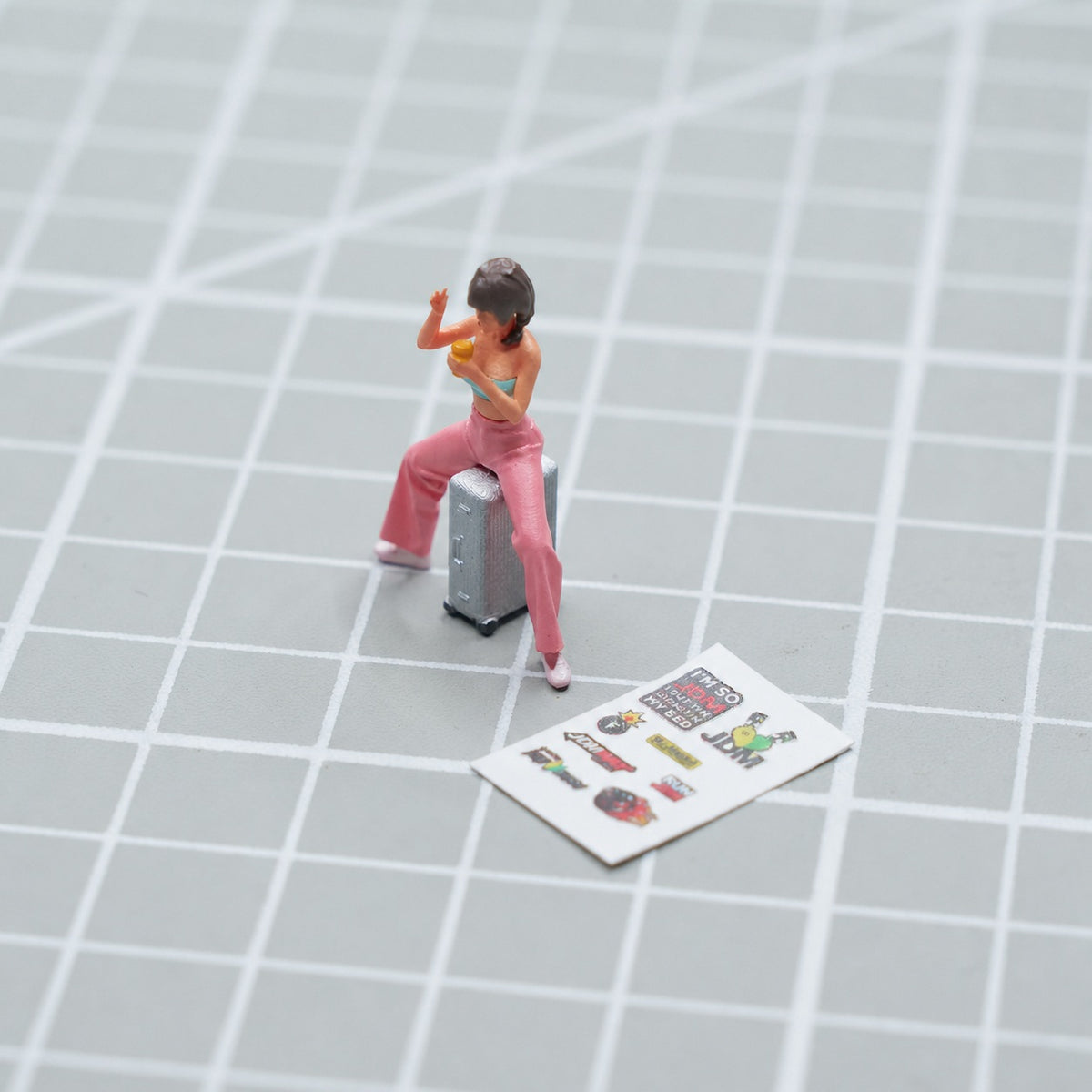 1:64 Street Hot Dog & Ice Cream Miniature Diorama Series - Woman in Pink High-Waisted Pants Sitting Astride a Suitcase Diorama Set